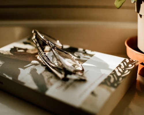 A book and reading glasses on a table