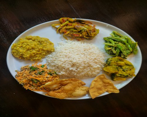 A well portioned plate of rice, dal, and vegetables